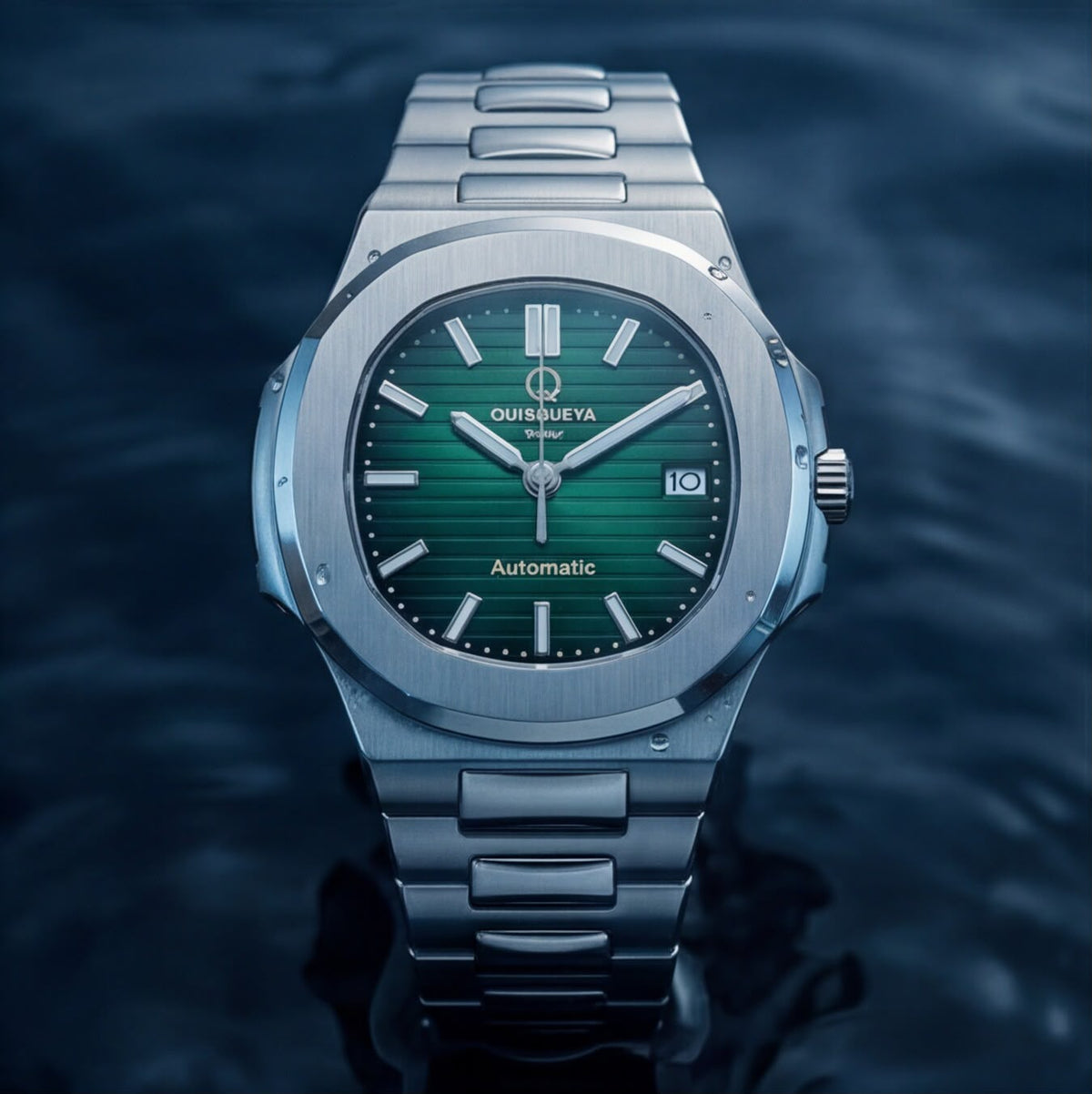 A Quisqueya Stellar automatic wristwatch with a brushed silver-tone stainless steel case and integrated bracelet, featuring a vibrant green dial and silver-tone hour markers, shown against a dark, water-textured background.